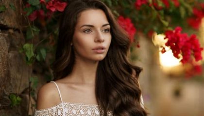 A Woman Standing In Front Of A Flower