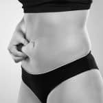 A Close Up Of A Person Grabbing Her Fat Belly